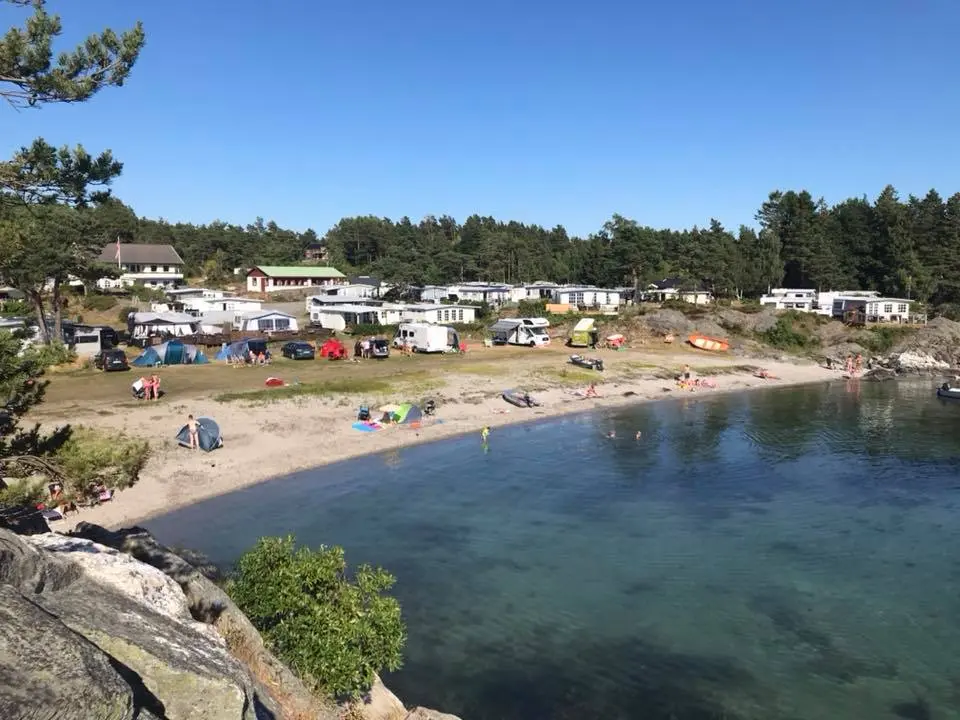 Badestranden ved Breivik Camping en sommerdag, med telt på plenen