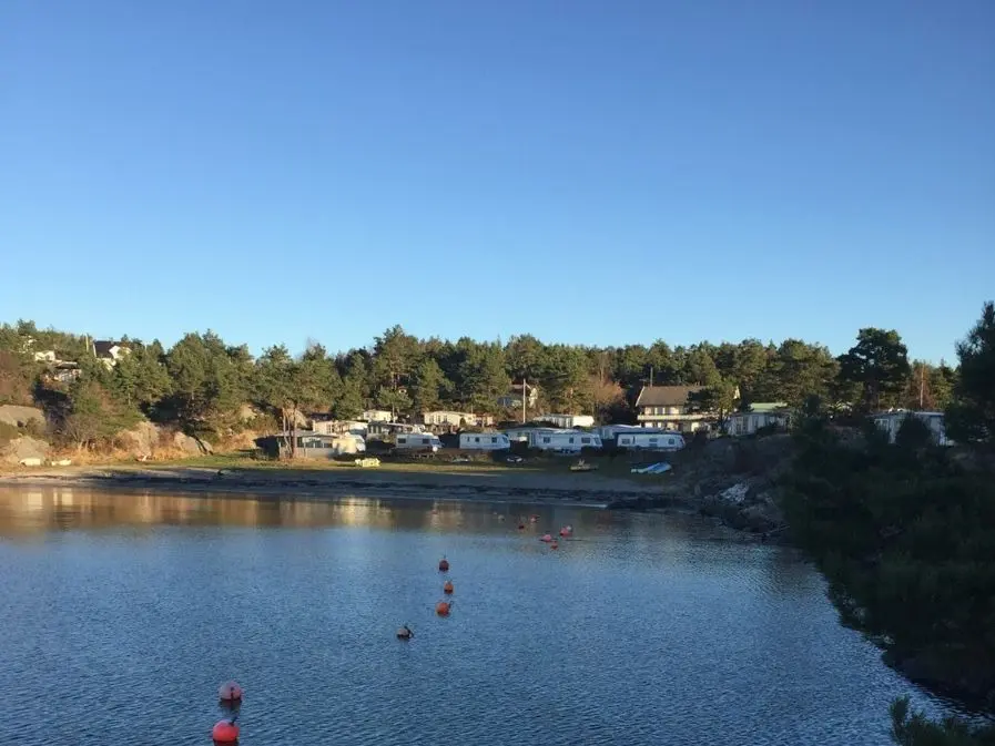 Bukta med bøyer og campingvogner ved skogkanten